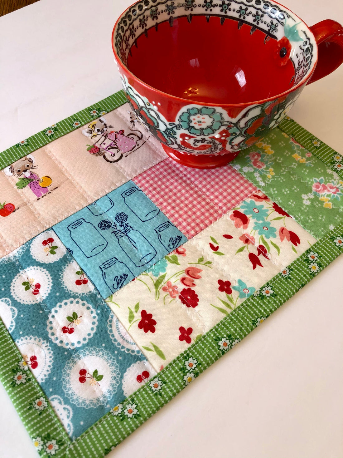 red mug sitting on patchwork table mat