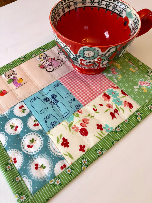 red mug sitting on patchwork table mat